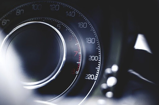 Car speedometer on a blurry dashboard
