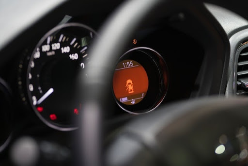 A steering wheel with car controls on a dashboard